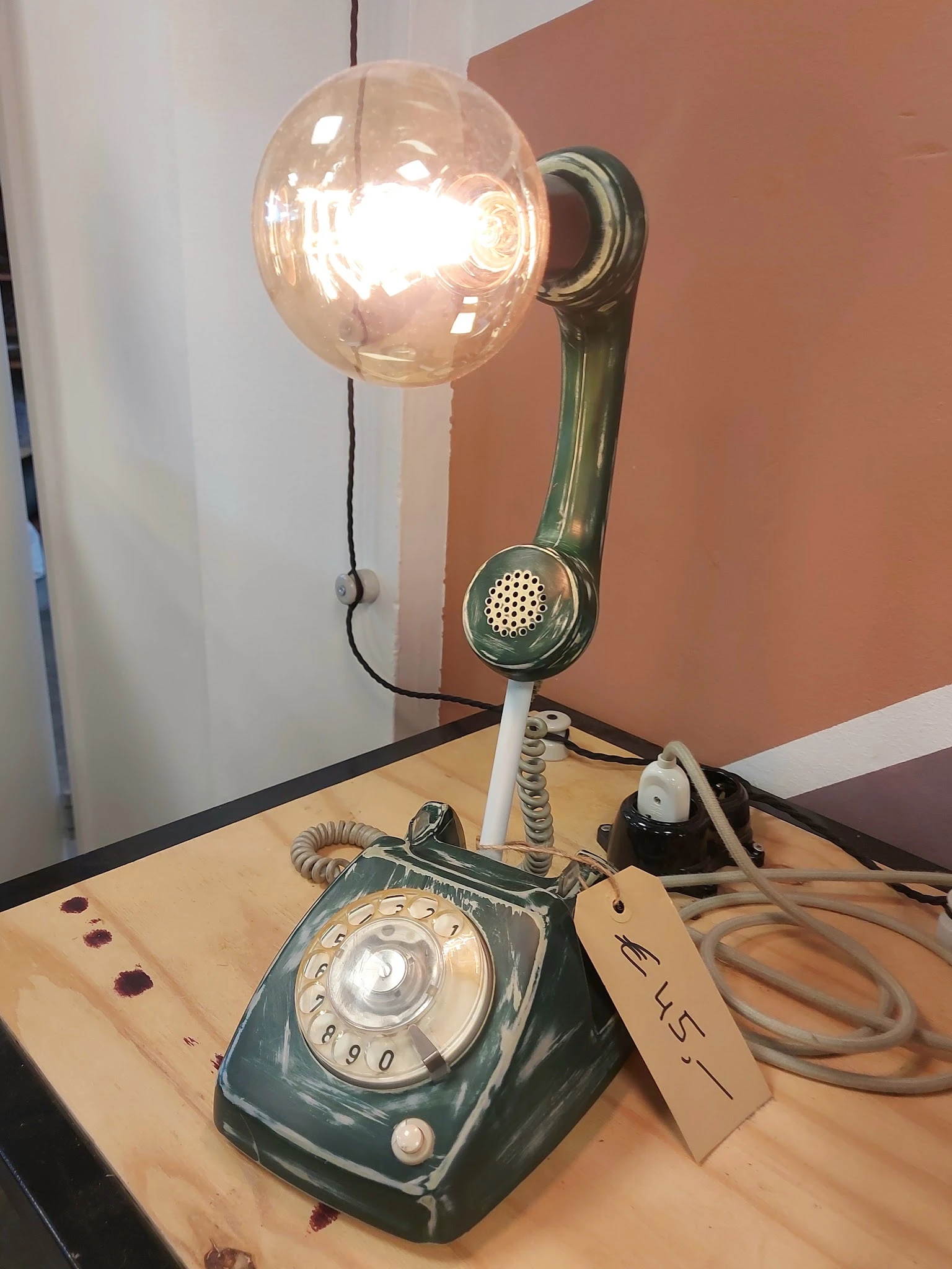 Vintage groene telefoon met hoorn en draaischijf, op houten ondergrond