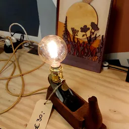 Sfeervolle tafellamp met glazen bol en houten voet, verlicht op een houten tafel