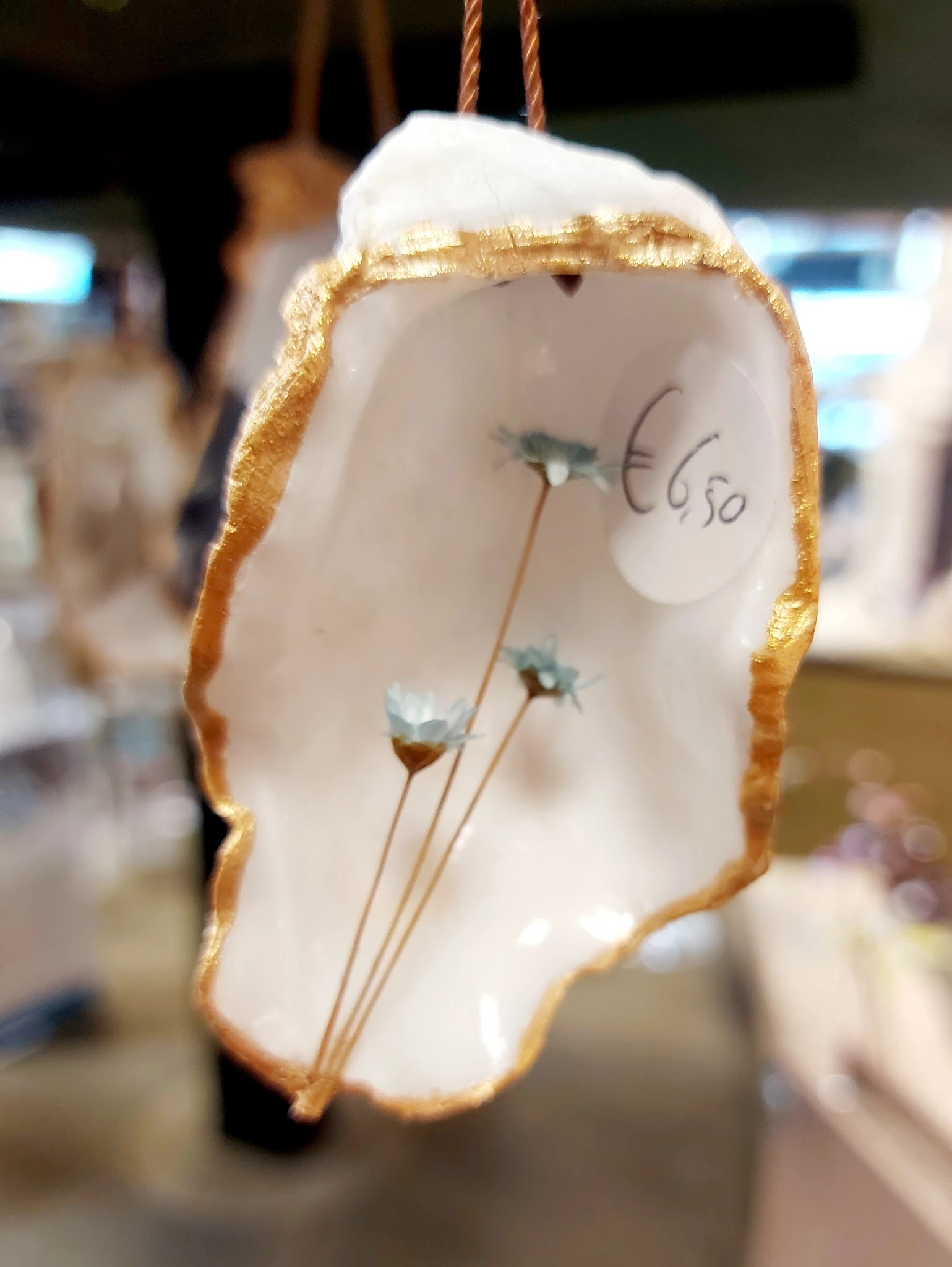 Witte decoratieve vaas met gouden rand en blauwe bloemen, prijskaartje €6,50