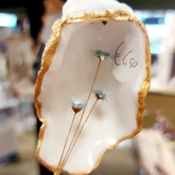 Witte decoratieve vaas met gouden rand en blauwe bloemen, prijskaartje €6,50