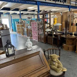 Winkelvloer van kringloopwinkel met diverse meubels, kasten, lampen en huishoudspullen uitgestald