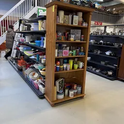 Houten kast en stellingen met huishoudelijke artikelen, servies en decoratie in de winkel