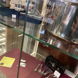 Glazen vitrinekast met decoratieve items en een geel prijskaartje