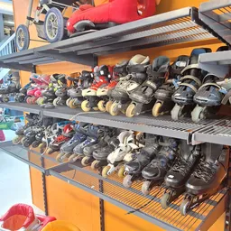 Metalen stellingen met grote verzameling tweedehands inline skates en rolschaatsen in verschillende maten en kleuren