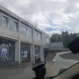 Gevel van kringloopwinkel Goedkoop & Zo aan Valkenstraat, met etalages en winkelentree zichtbaar