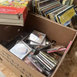 Kartondoos met tweedehands cd's, dvd's en mediaspelers