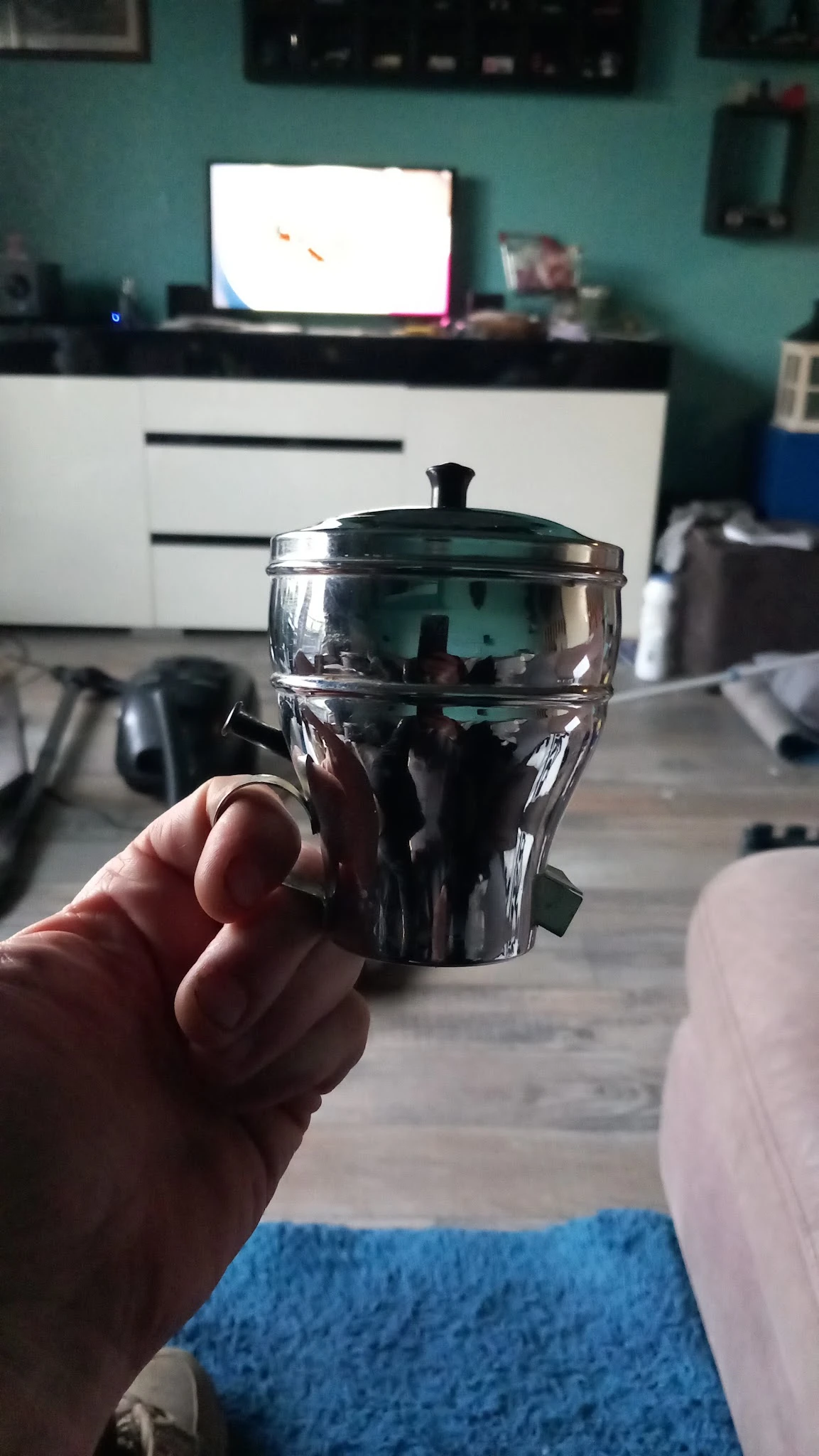 Glazen schaal met deksel en zwarte handgrepen, close-up in hand