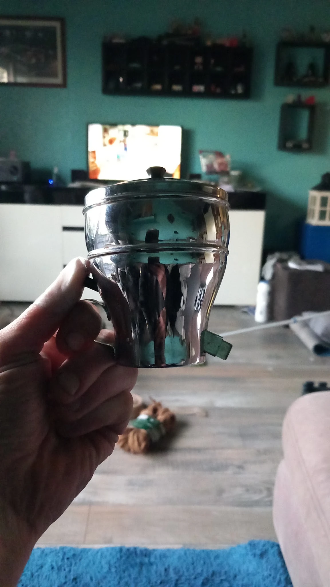 Doorzichtige kunststof beker met zwart deksel, gehouden in een hand
