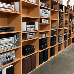 Grote houten stellingkast vol met vintage audio- en elektronicaapparatuur zoals versterkers, receivers en speakers