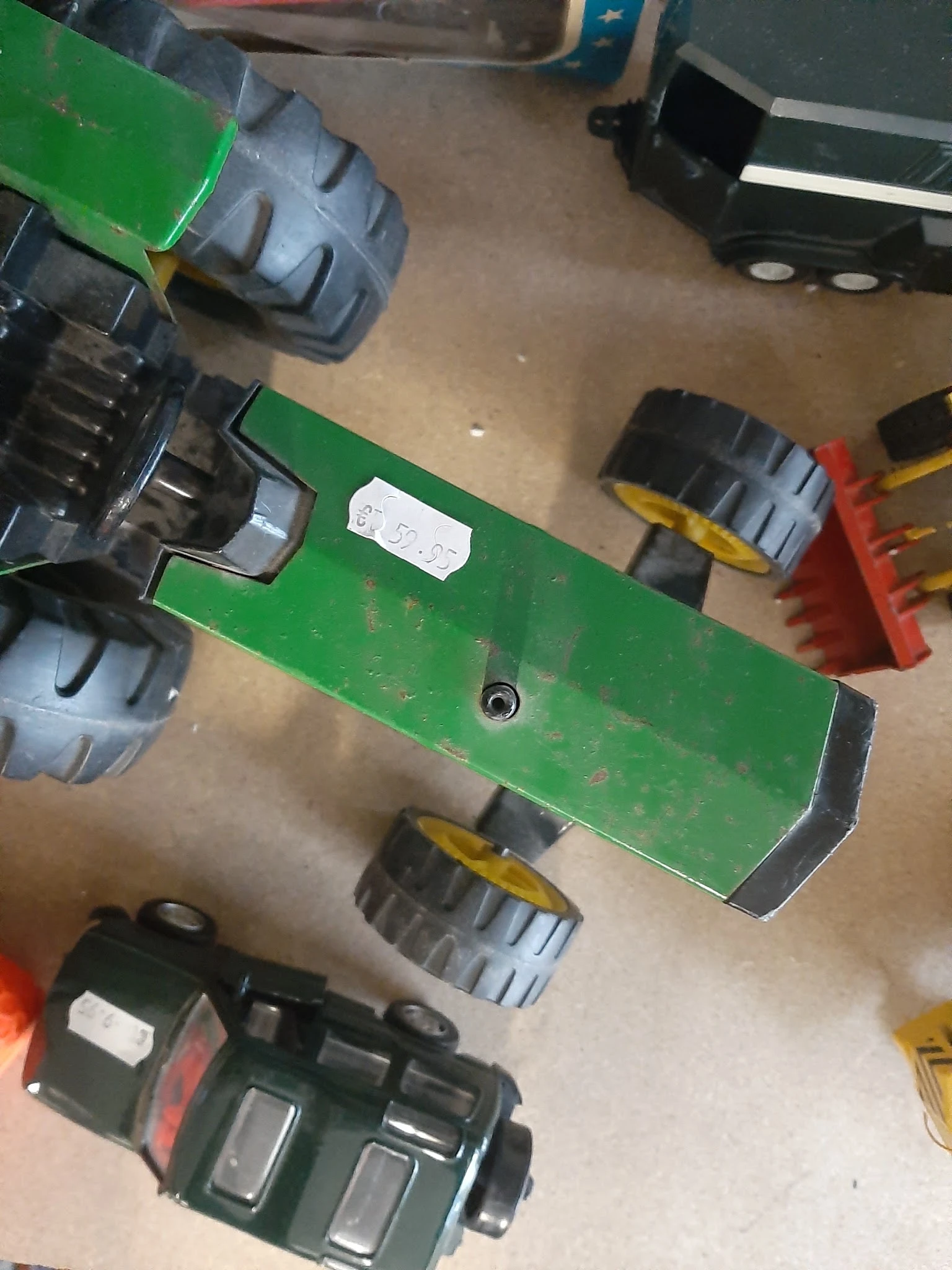 Groen speelgoedvoertuig met wielen gezien van bovenaf op betonnen vloer