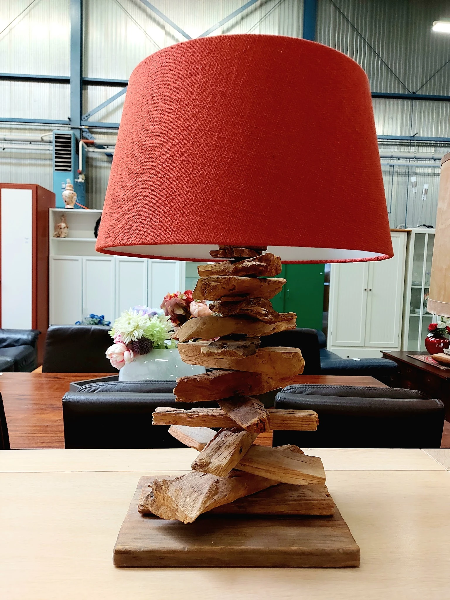 Houten decoratieve lamp met rode stoffen kap, opgebouwd uit gestapelde houten blokken