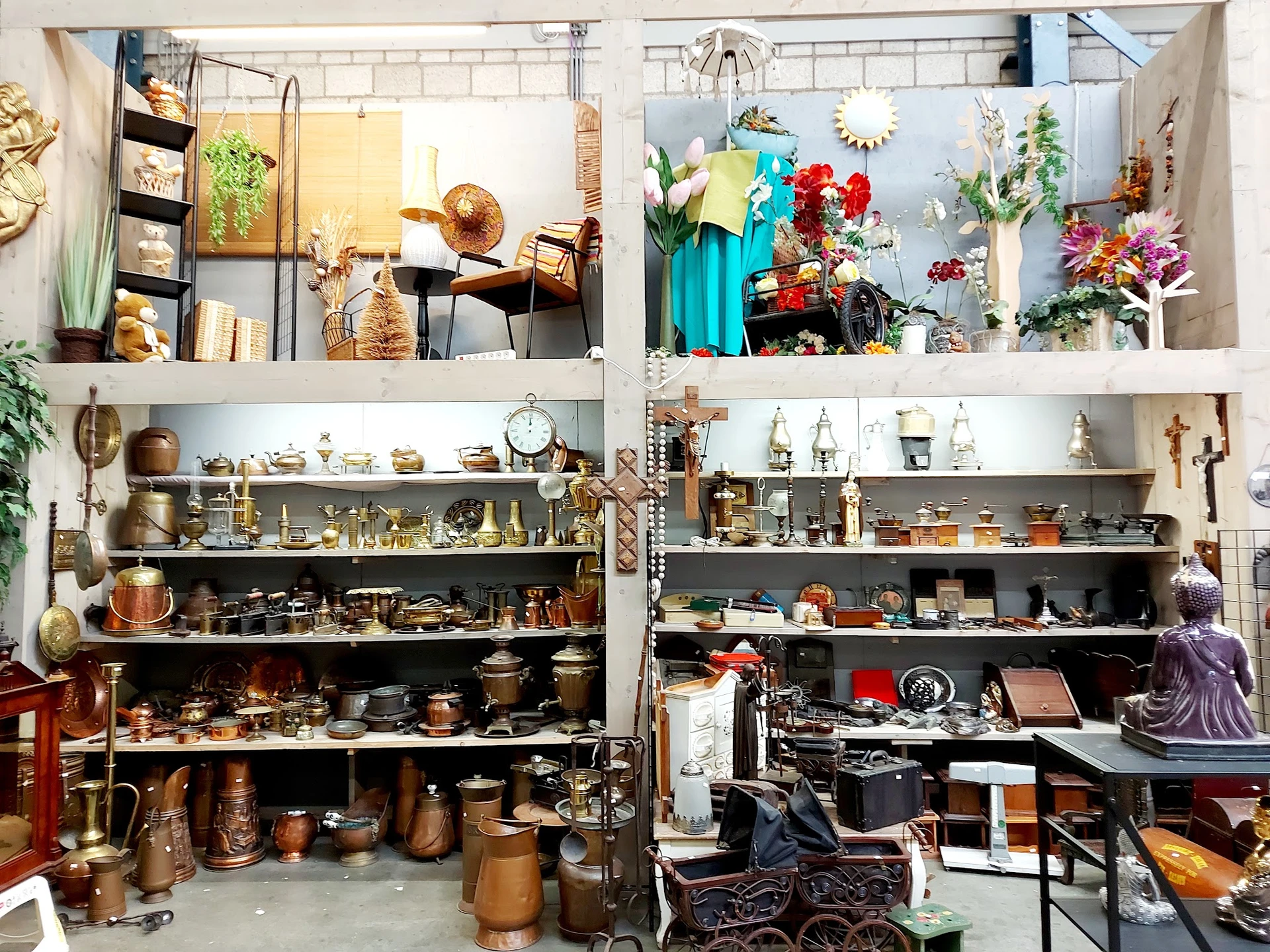 Kasten vol met tweedehands huishoudartikelen, decoratie en verschillende verzamelbakken in de kringloopwinkel