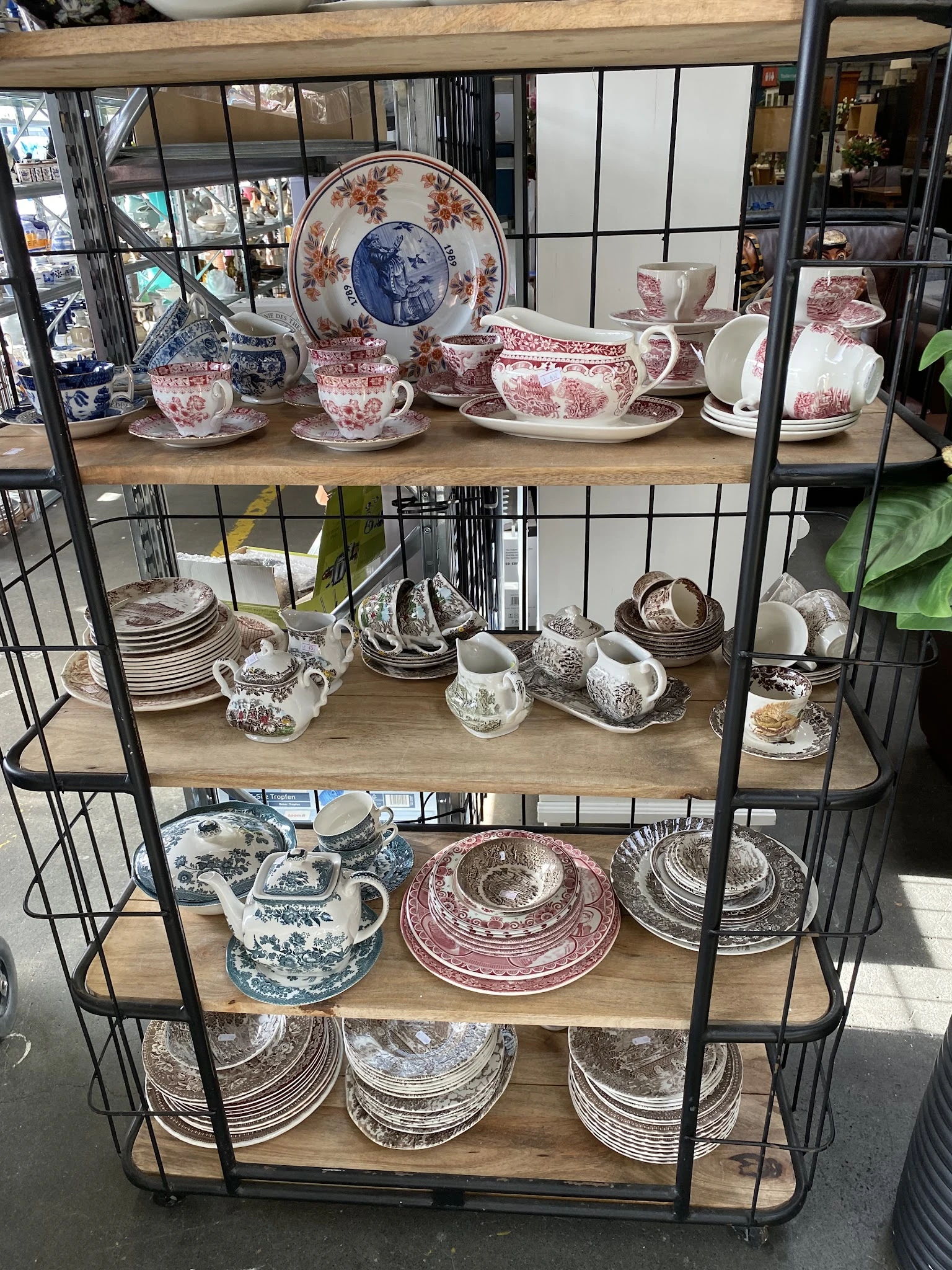 Stellingkast met verzameling porselein servies in wit met blauwe en rode decoraties