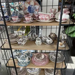 Stellingkast met verzameling porselein servies in wit met blauwe en rode decoraties