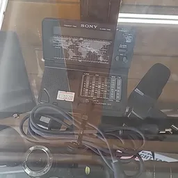 Sony transistorradio met bijbehorende koptelefoon en voeding op tafel