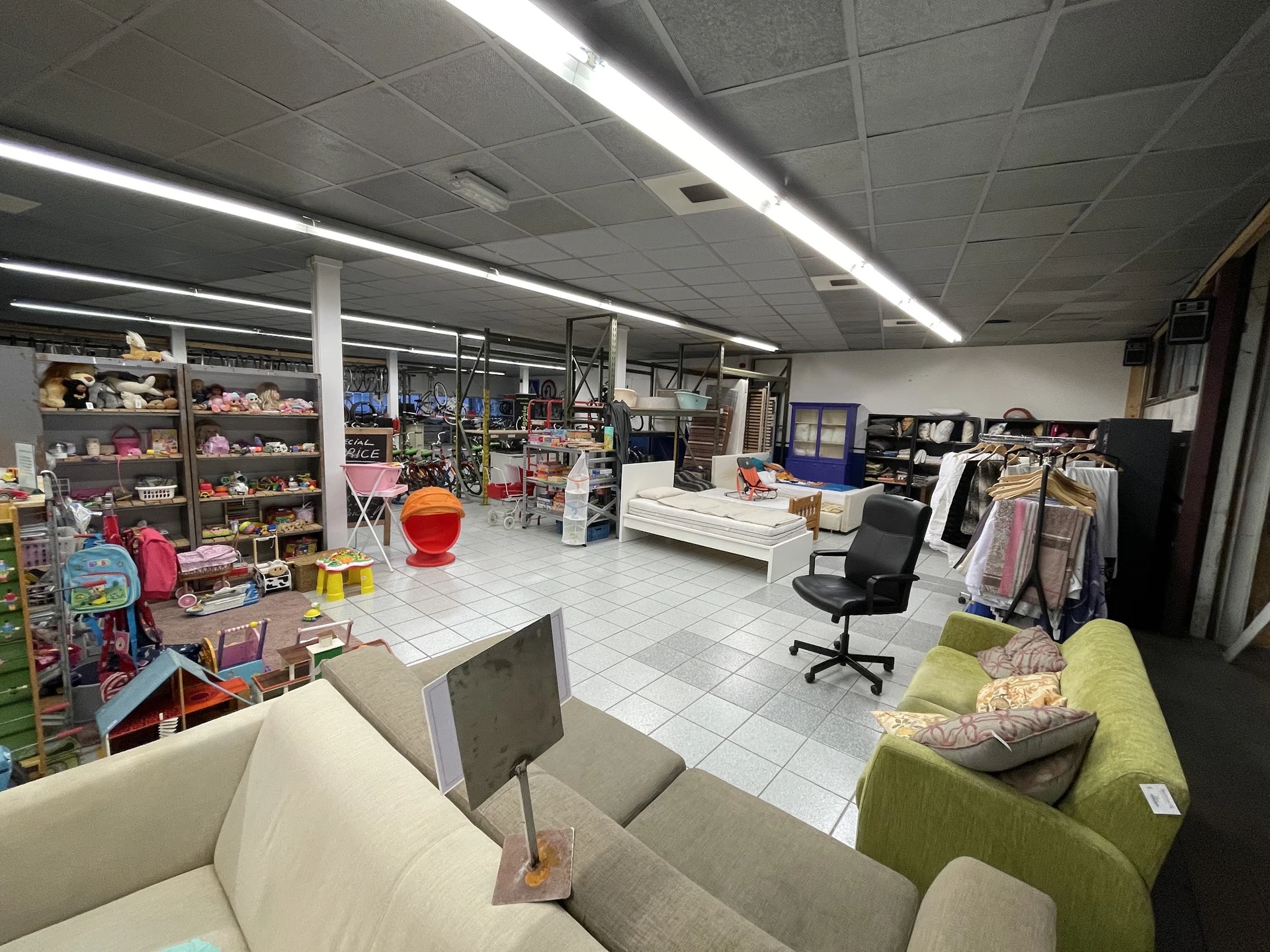 Winkelvloer van kringloopwinkel met stellingen, meubels, en diverse tweedehands artikelen