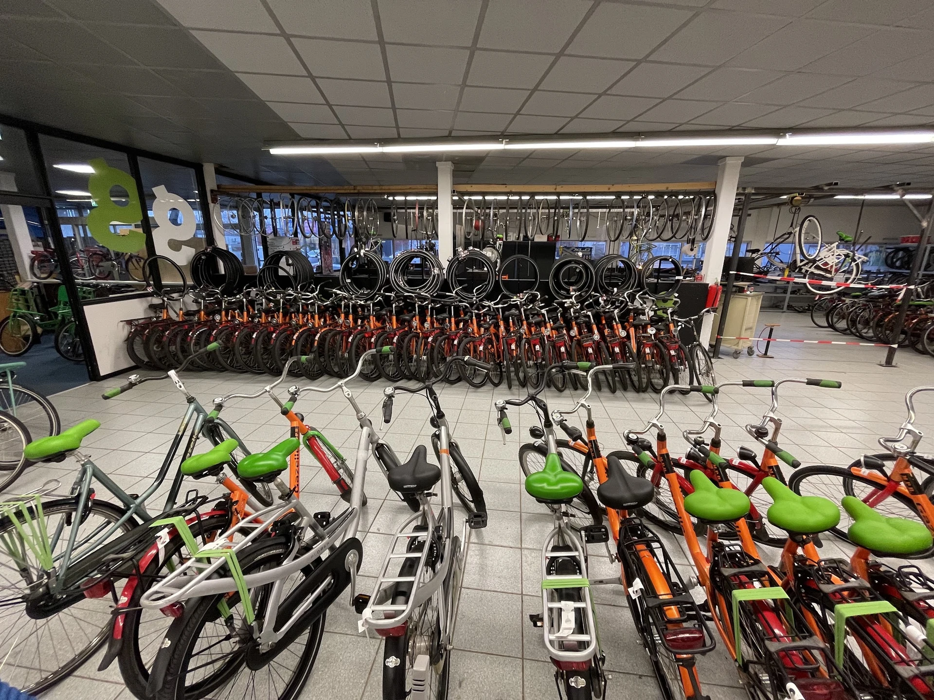 Grote verzameling tweedehands fietsen in verschillende kleuren uitgestald in de winkel
