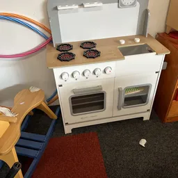 Wit speelgoedkeukenset met twee ovens, vier kookplaten en houten werkblad in kringloopwinkel