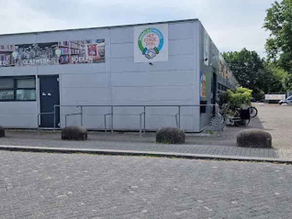 Witte gevel van kringloopwinkel Het Goede Doel met logo, ingang en ramen