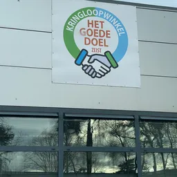 Logo van Het Goede Doel Zeist met handdruk en tekst op witte wand