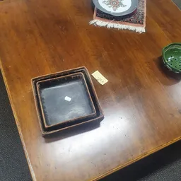 Bruine vierkante schaal of dienblad met donkere bodem op houten tafel