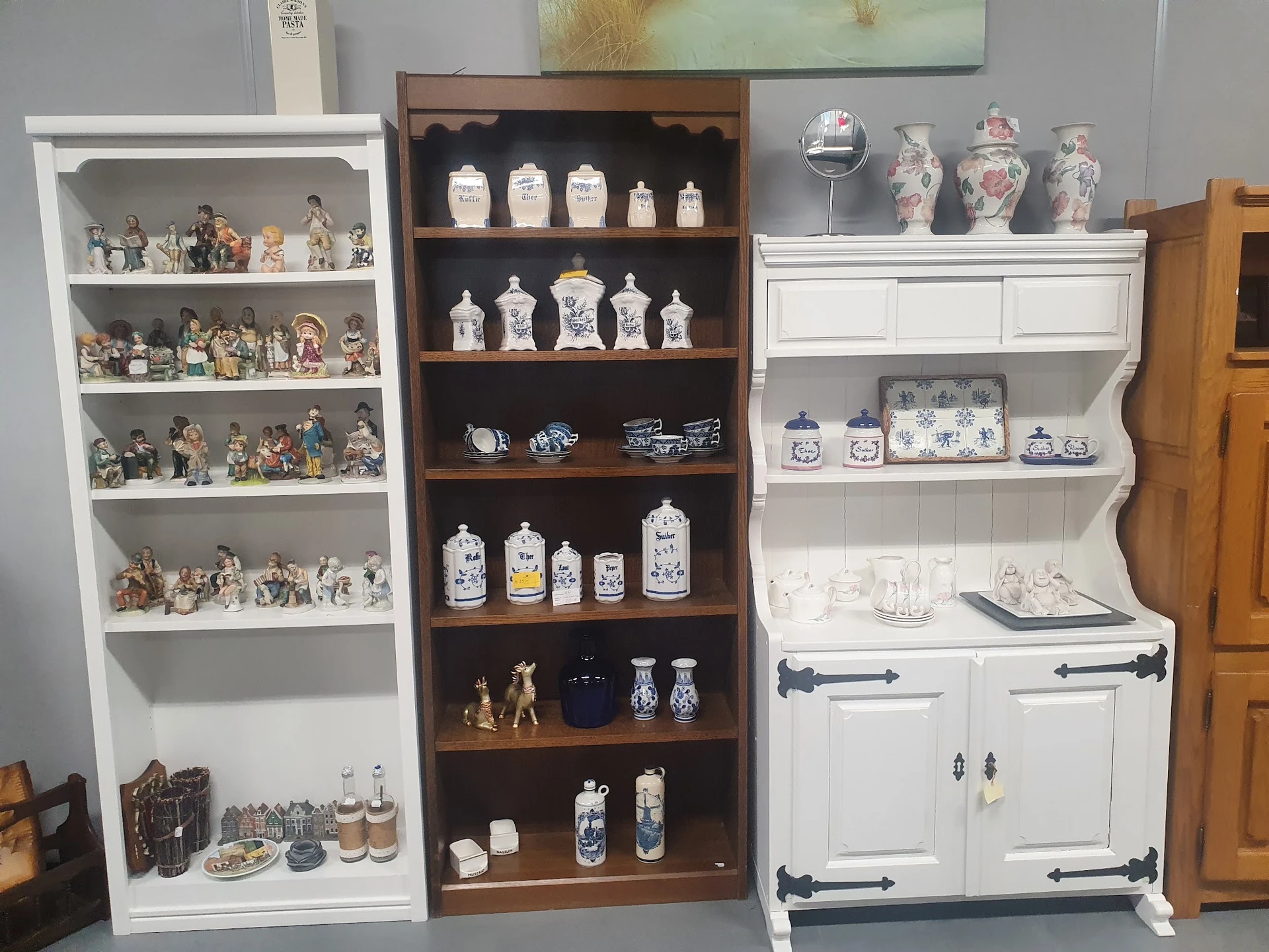 Vitrinekasten met verzamelstukken: porselein, miniaturen en decoratieve objecten netjes uitgestald