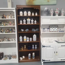 Vitrinekasten met verzamelstukken: porselein, miniaturen en decoratieve objecten netjes uitgestald