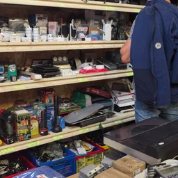 Volle stellingen met diverse gebruikte artikelen zoals gereedschap, elektronica en huishoudartikelen
