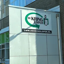 Gevel van kringloopwinkel De Kringloper met groen logo en website-adres