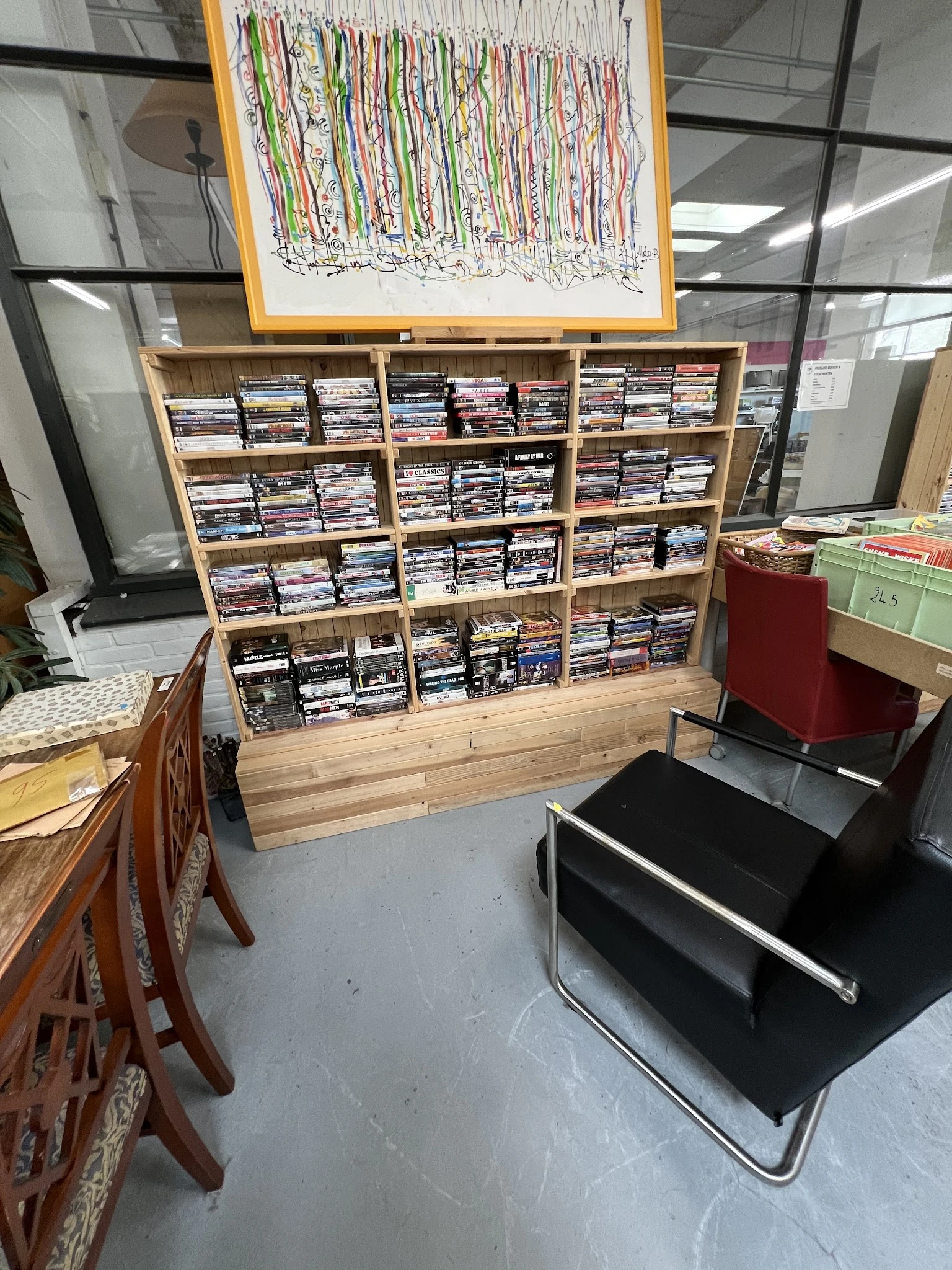 Houten stellingkast gevuld met grote hoeveelheid dvd's en blu-rays netjes georganiseerd in vakken