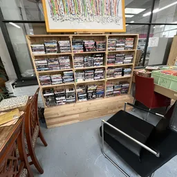 Houten stellingkast gevuld met grote hoeveelheid dvd's en blu-rays netjes georganiseerd in vakken
