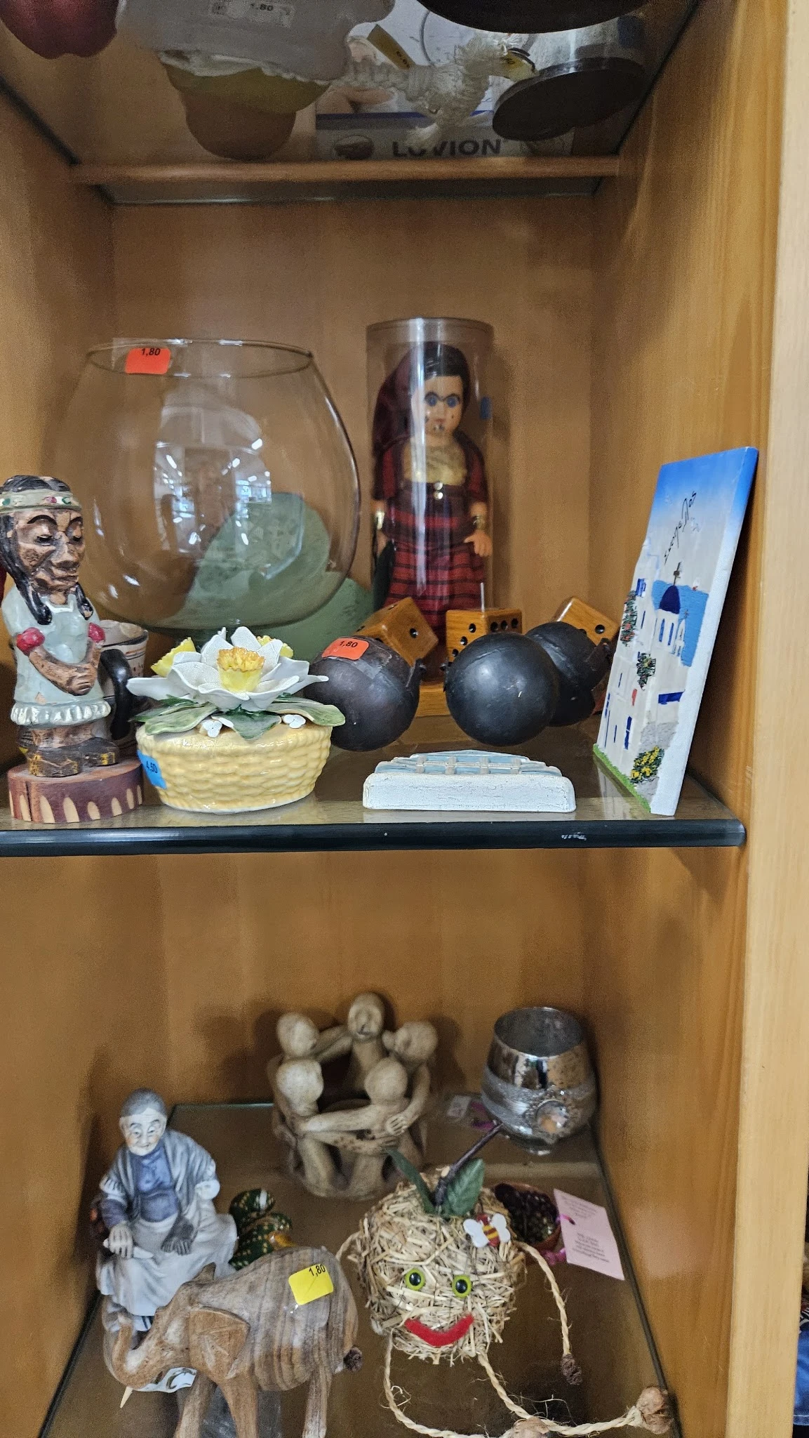 Kastplank met diverse decoratieve items zoals beeldjes, vazen, bloemen en kleine kunstwerken.