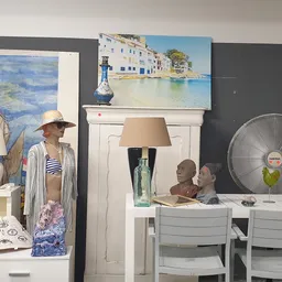 Winkelinterieur met uitgestalde meubels, een ventilator, kunstwerk aan de muur en etalagepop met kleding