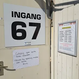 Deurkozijn met ingangnummer 67 en openingstijdenschema