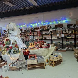 Winkelinterieur met kerstdecoratie, grote witte kerstman, stellingen met spullen en feestversiering