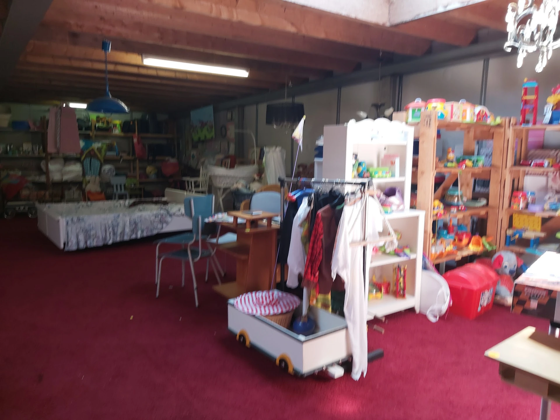 Winkelvloer met speelgoed, kleding en verschillende afdeling in een kringloopwinkel