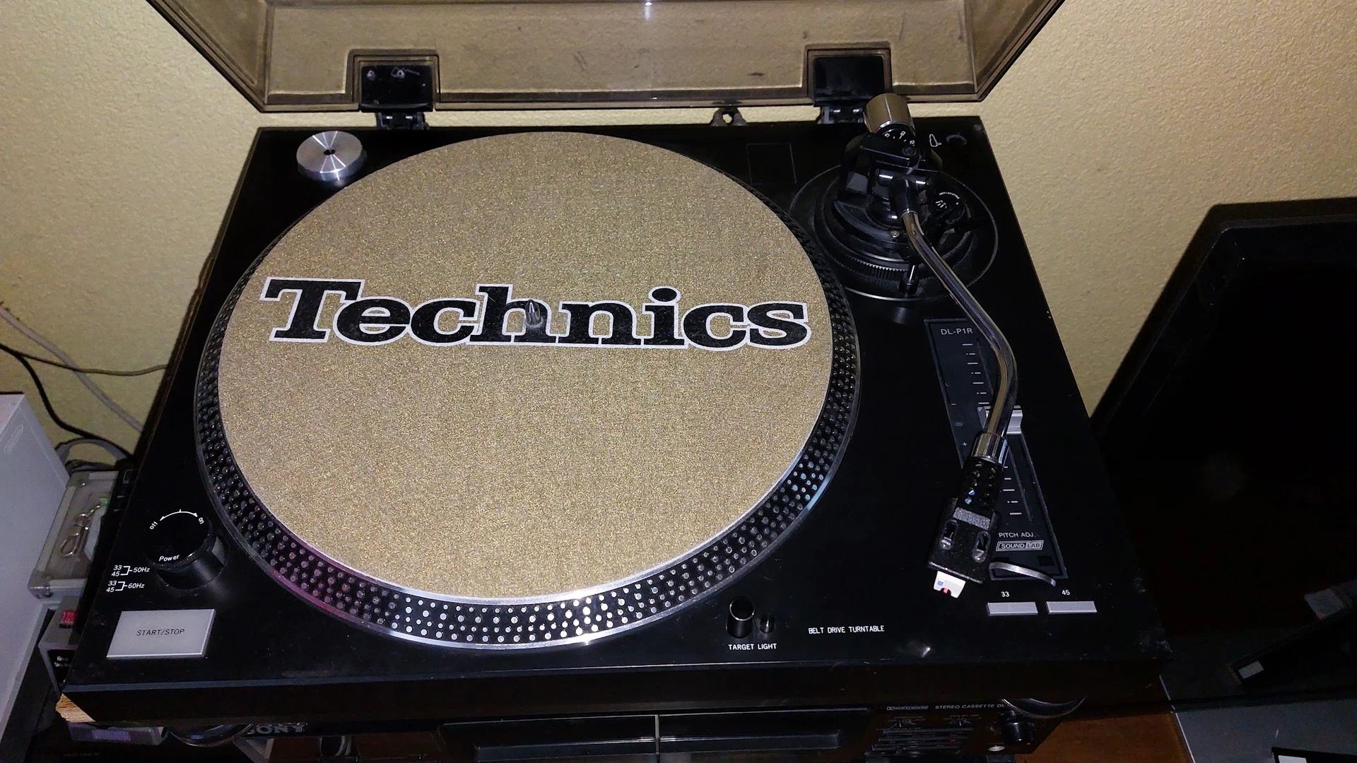 Technics draaitafel met beige slipmat en zwarte tonearm in geopende koffer