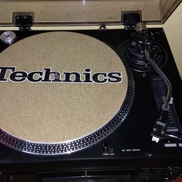 Technics draaitafel met beige slipmat en zwarte tonearm in geopende koffer