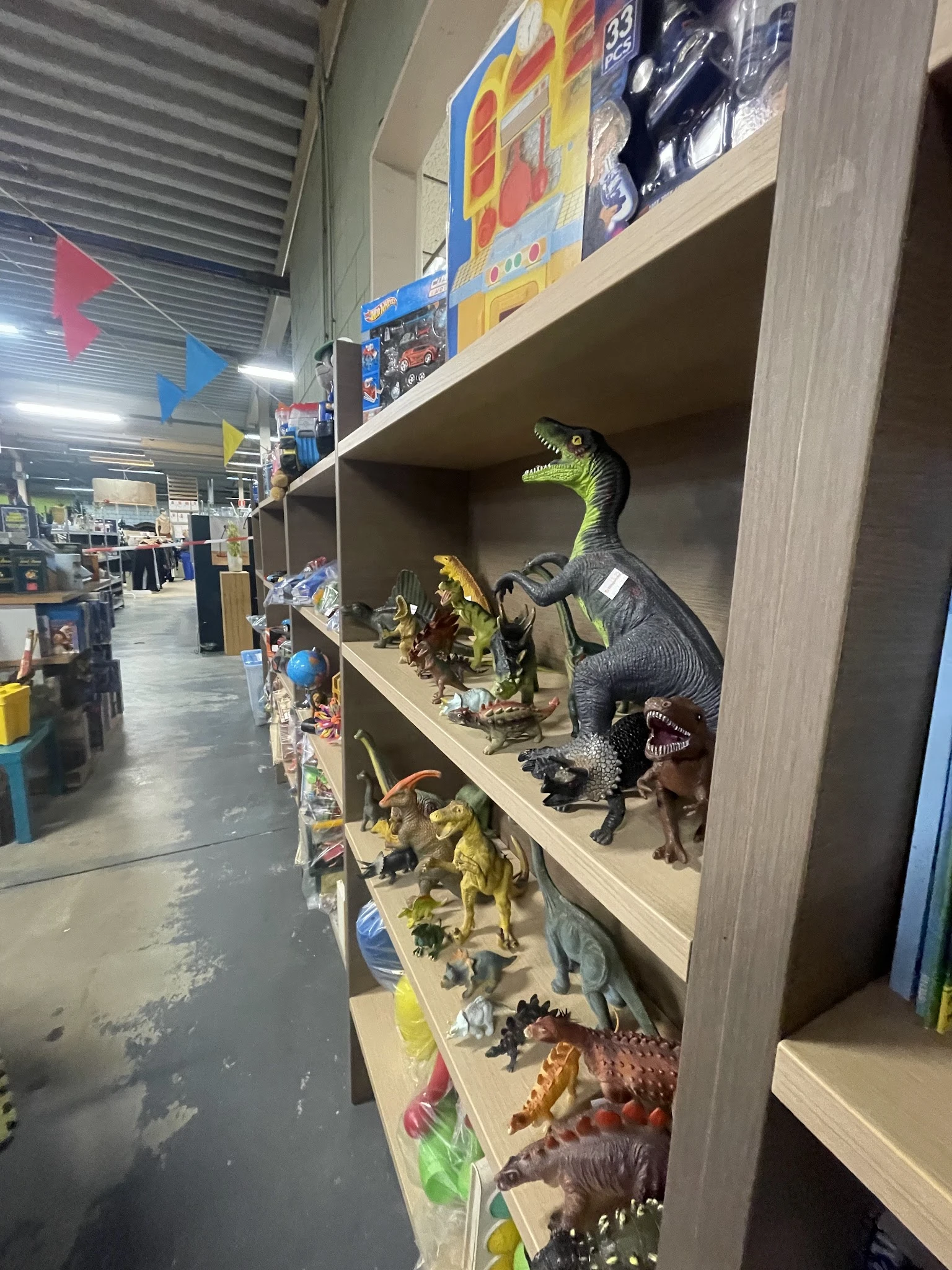 Stellingen met uitgestalde dinosaurusfiguren en speelgoedbeesten in verschillende maten en kleuren