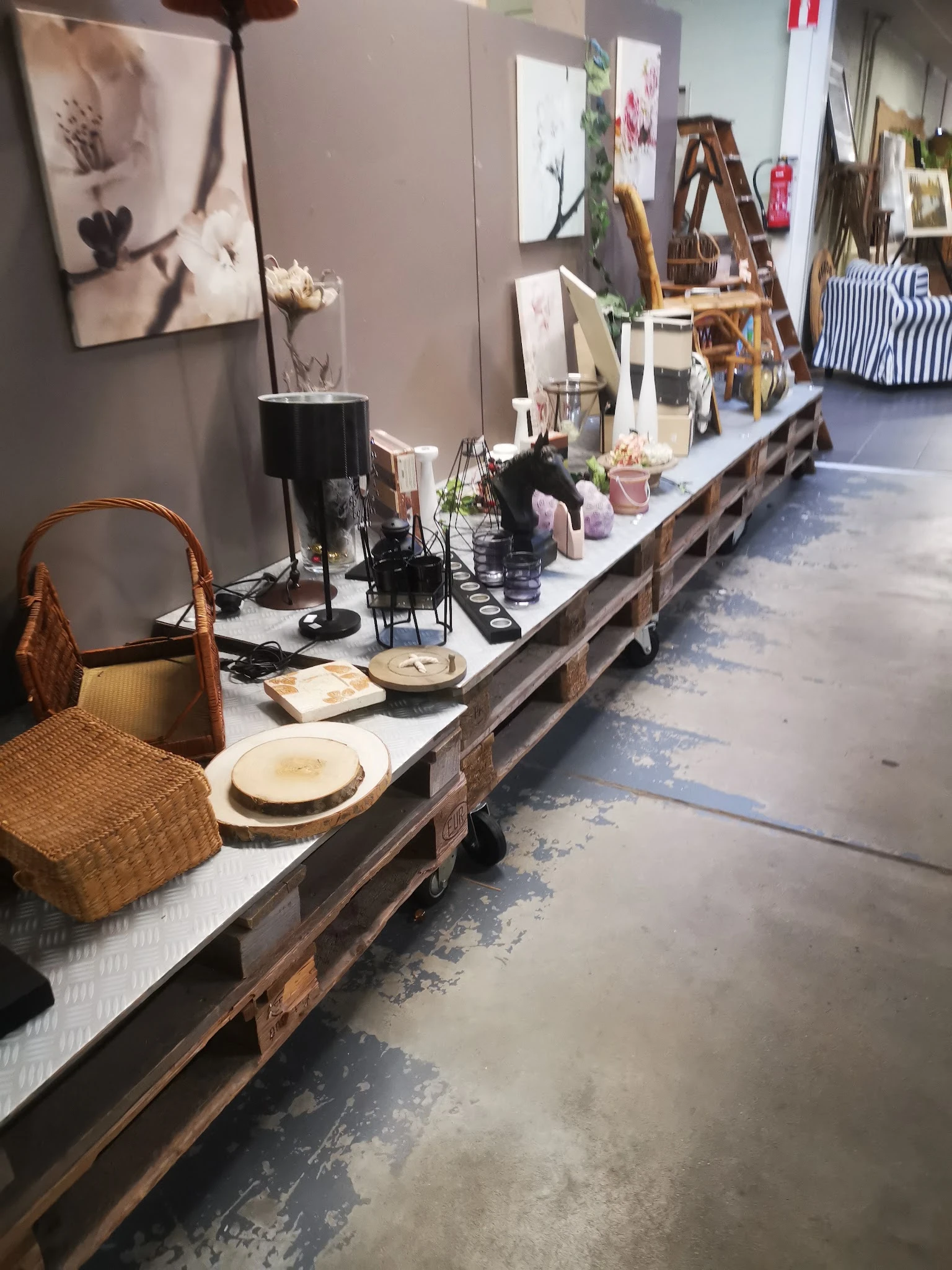 Uitgestalde serviesgoed, accessoires en decoratieve items op een lange tafel in de winkel