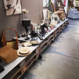 Uitgestalde serviesgoed, accessoires en decoratieve items op een lange tafel in de winkel