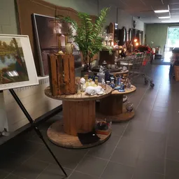 Winkelvloer met houtenDisplaytafels, kunstwerken, planten en decoratieve artikelen in kringloopwinkel