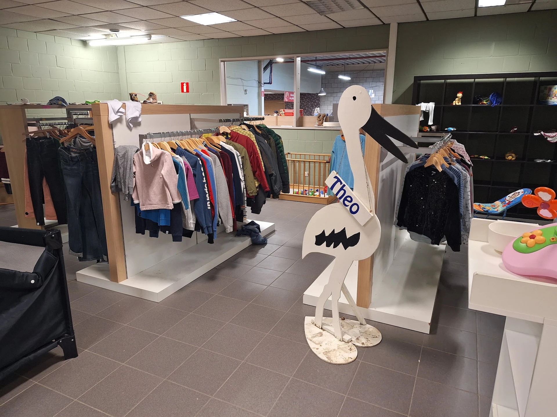 Winkelinterieur met kledingrekken, etalagepop en speelgoed in een kringloopwinkel
