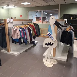 Winkelinterieur met kledingrekken, etalagepop en speelgoed in een kringloopwinkel