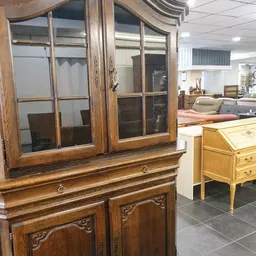 Houten buffetkast met glazen deuren en houten onderkast met decoratieve details