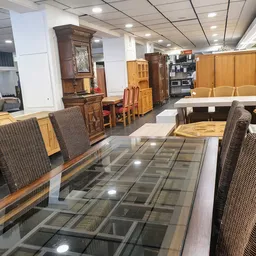 Winkelvloer met uitgestalde meubels, stoelen en kasten in een kringloopwinkel