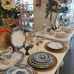 Uitgestald servies en tafelgerei met blauwe decoratie op witte ondergrond in de winkel