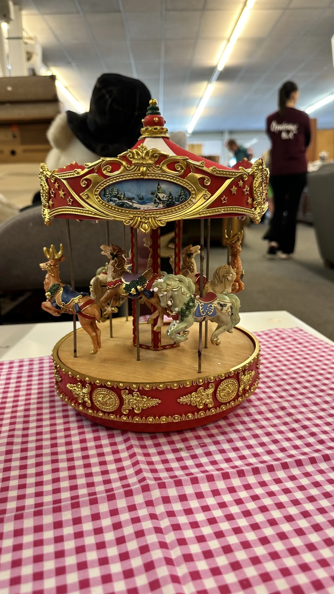 Goudkleurige draaimolen met rood en goud decoratief dak en vier paarden.