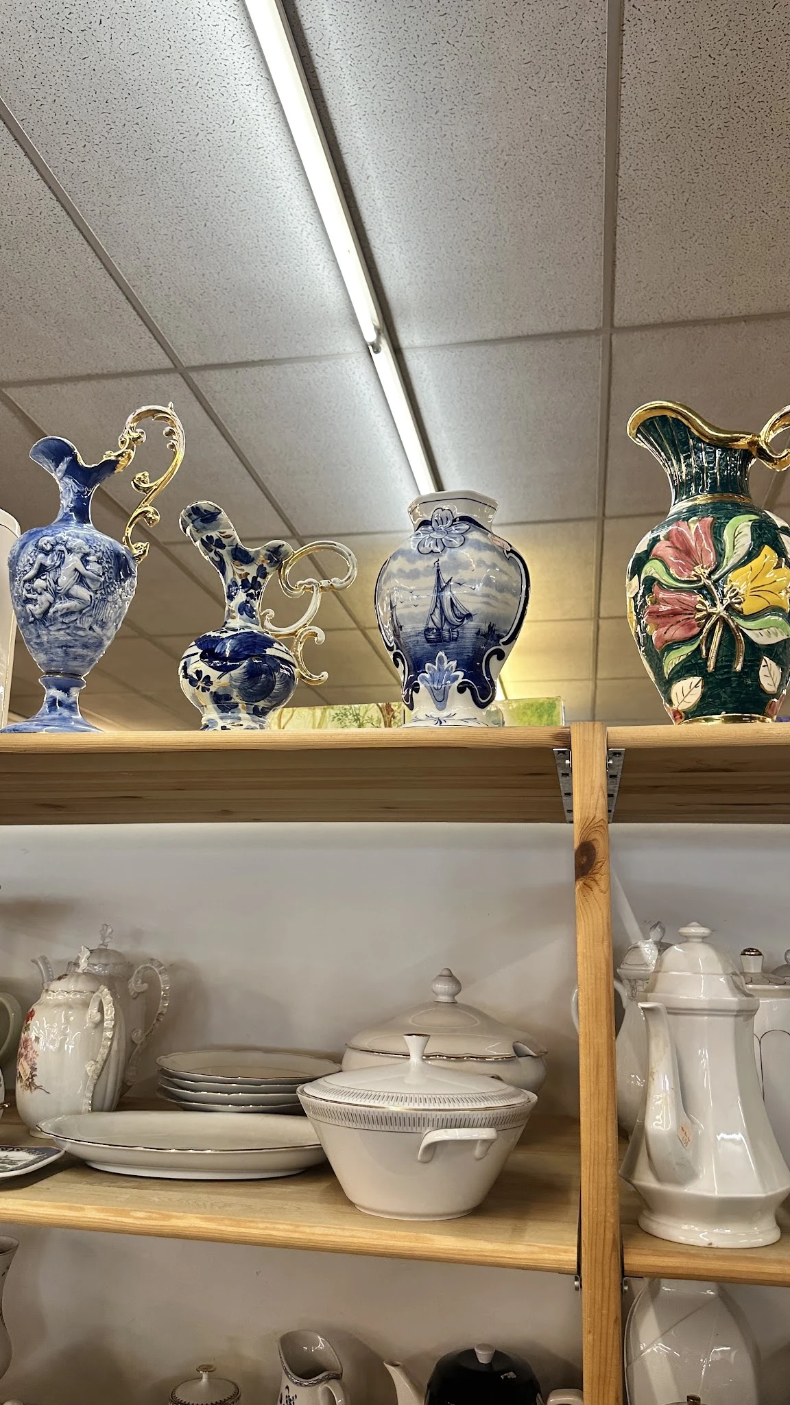 Glazen vazen en schalen met decoratieve motieven op een houten plank in de winkel