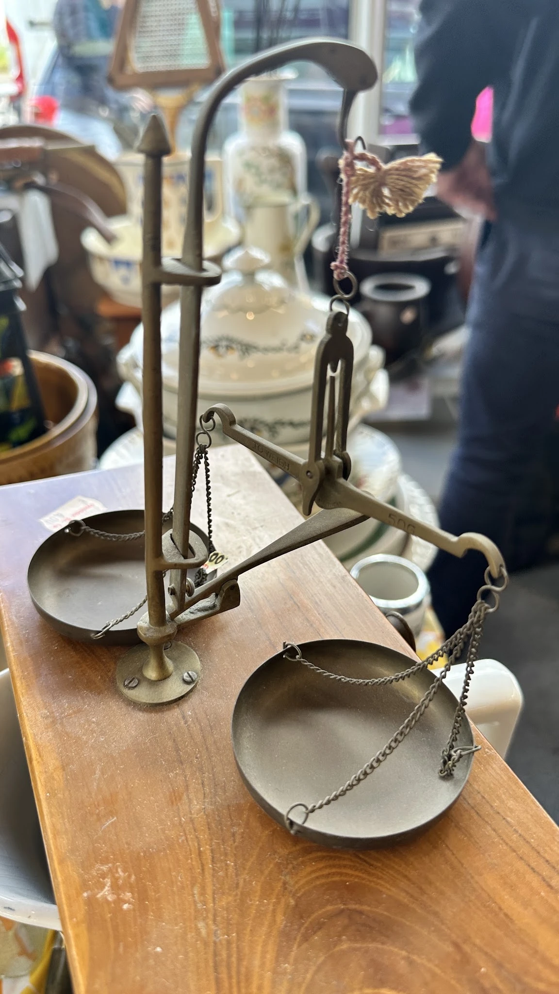 Close-up van een vintage balansweegschaal met twee metalen schalen, op houten basis